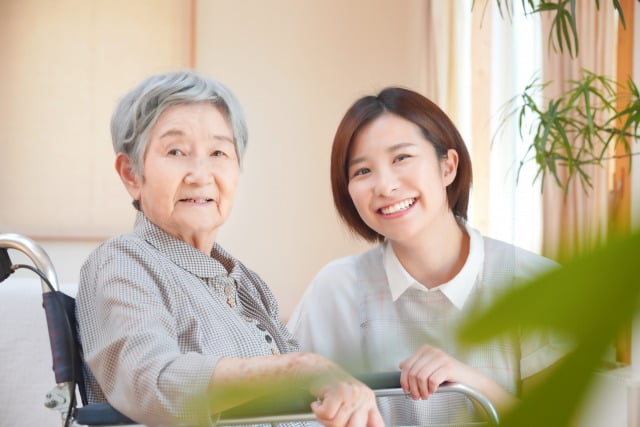 高齢者に笑顔で接する介護士の女性